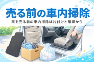 ドアを開けた車内のシートを掃除機で掃除している手元と、外に出した私物の箱